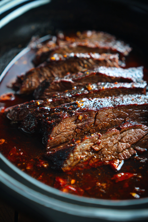 skirt steak slow cooking in crock pot with sauce