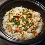 chicken rice with rice cooker topped with herbs and chilies