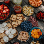 Fresh camp snacks including fruits, crackers, and trail-friendly bites on a picnic table